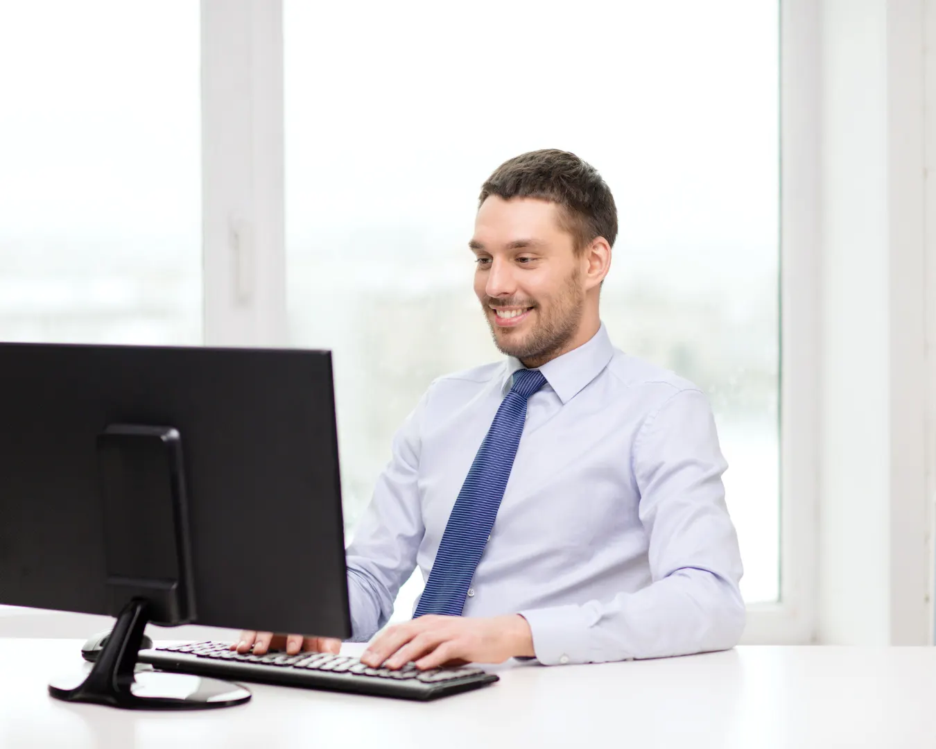 Berater arbeitet lächelnd am Computer